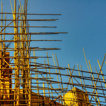 Beyond the Naked Eye: How Predictive Maintenance Is Redefining Structural Safety Yenem Structural Engineers Bamboo scaffolding on a building under construction against a clear blue sky showing expertise in predictive maintenance.