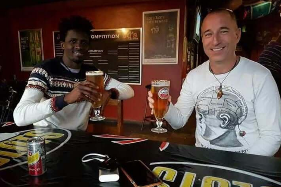 From Sponsor Child to Employee Yenem Structural Engineers Two men toasting beers at a bar. Sponsor child success story.