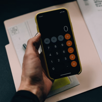 Calculator on phone with structural engineering consulting documents.