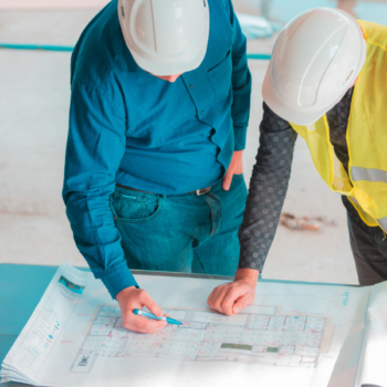 Construction workers doing structure assessment review for building plans.
