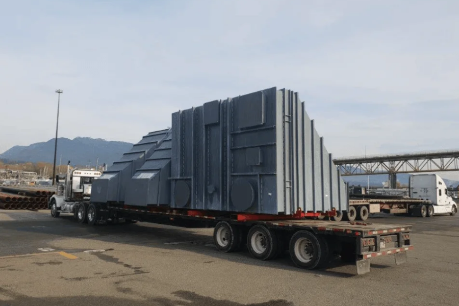 Transport Engineering: The Hidden Loads No One Talks About Yenem Structural Engineers Oversized load: a large, gray industrial component on a flatbed truck for transport engineering.