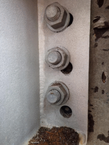 Structural integrity concern shown in misaligned bolts on steel connection.