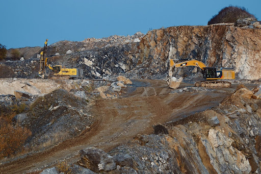 Excavators operating in a rocky mining environment.